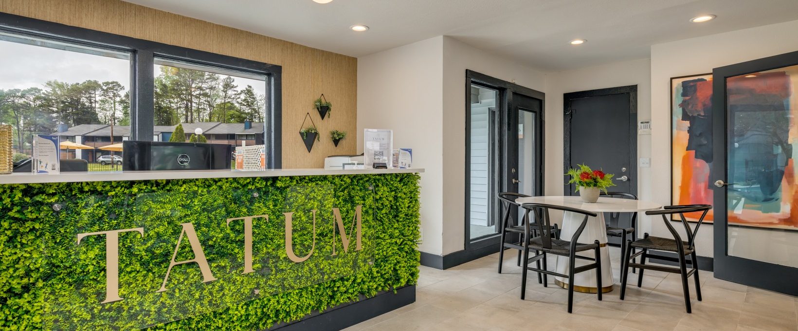 the reception area of a hotel with plants on the wall at The  Tatum