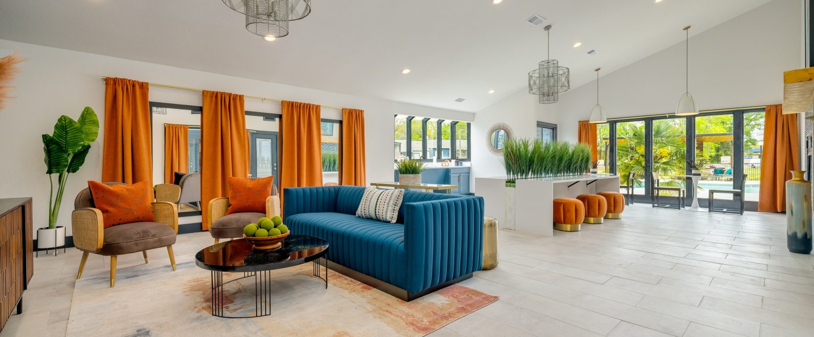 a living room with orange curtains and blue furniture at The  Tatum